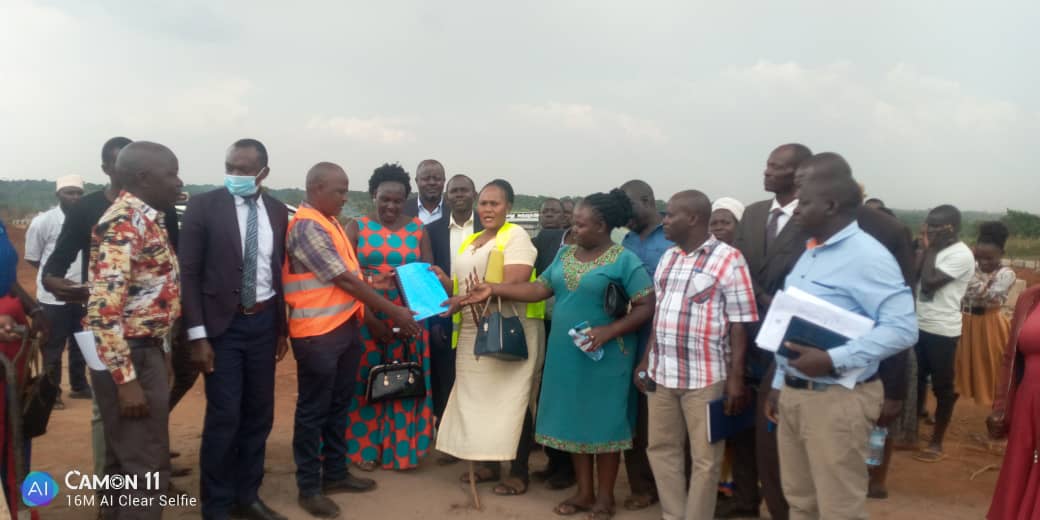 District leadership (RDC, CAO, LCV C/Pn) handing over iron sheets to Magogo S/C chief, LC3 C/P, headteachers, SMC &amp; PTA members.